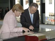 Chancellor Angela Merkel and the Secretary-General of the United Nations Ban Ki-moon look at a book together